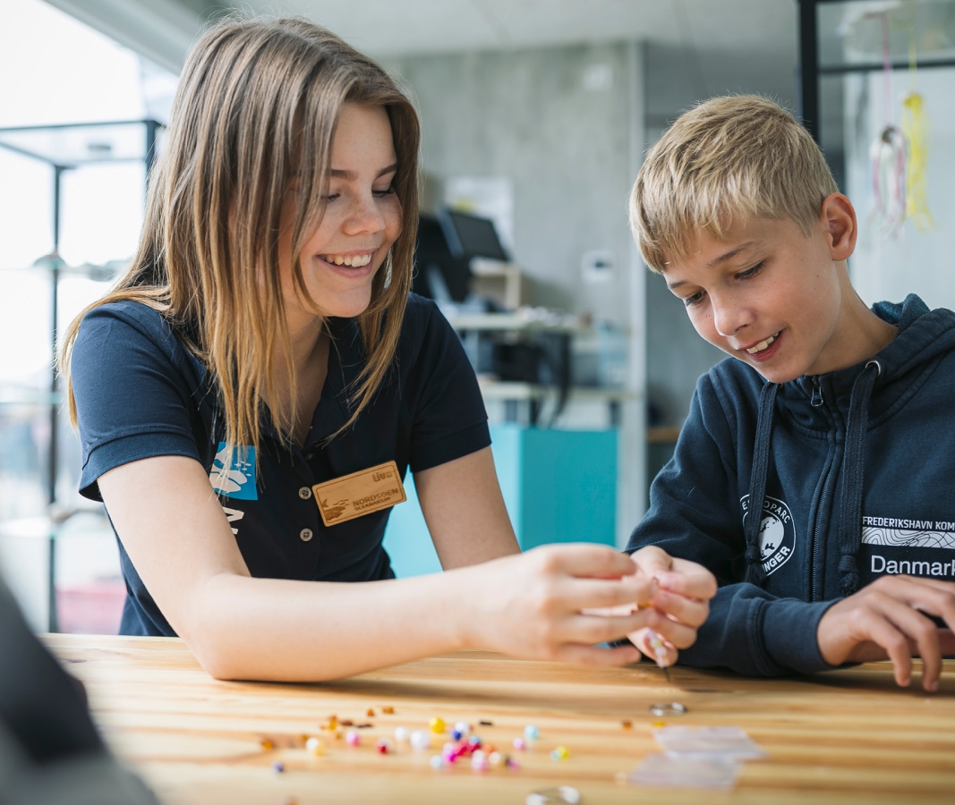 Medarbejder fra Nordsø Oceanarium sidder med barn